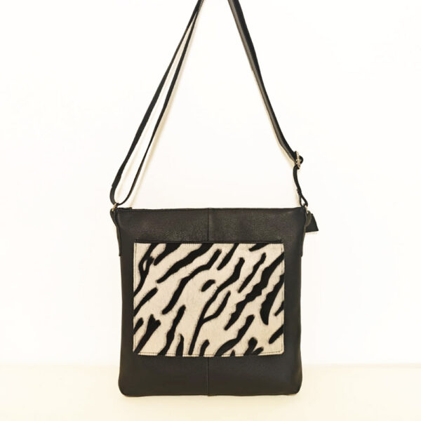 Tienda online de artículos hechos a mano en cuero y piel. Artesanos del cuero. Bolso bandolera con bolsillo de pelo print animal Imagen de WhatsApp 2025 09 01 a las 09.11 Bolso de piel negro cebra