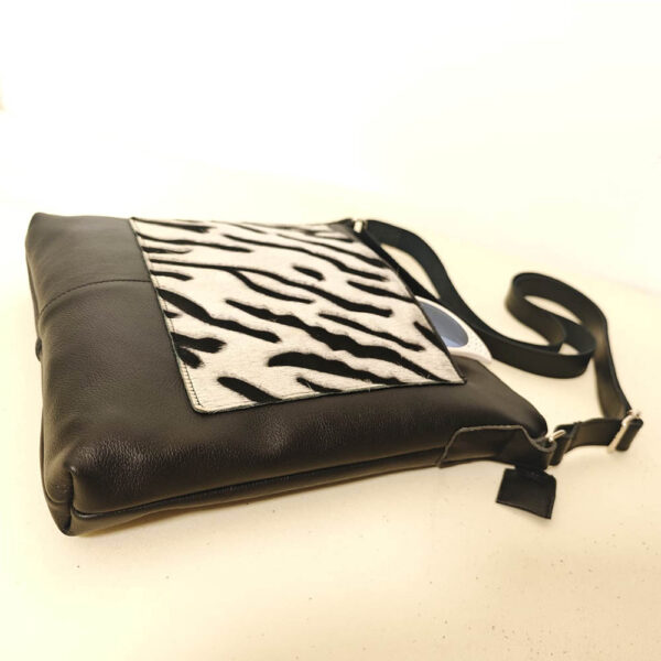 Tienda online de artículos hechos a mano en cuero y piel. Artesanos del cuero. Bolso bandolera con bolsillo de pelo print animal Imagen de WhatsApp 2025 09 01 a las 09.11.32 ee72d08f Bolso de piel negro cebra