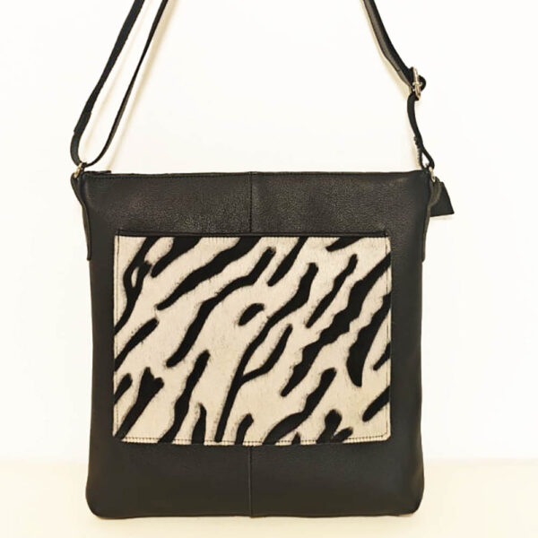 Tienda online de artículos hechos a mano en cuero y piel. Artesanos del cuero. Bolso bandolera con bolsillo de pelo print animal Imagen de WhatsApp 2025 09 01 a las 09.11.33 cde4a3e1 Bolso de piel negro cebra